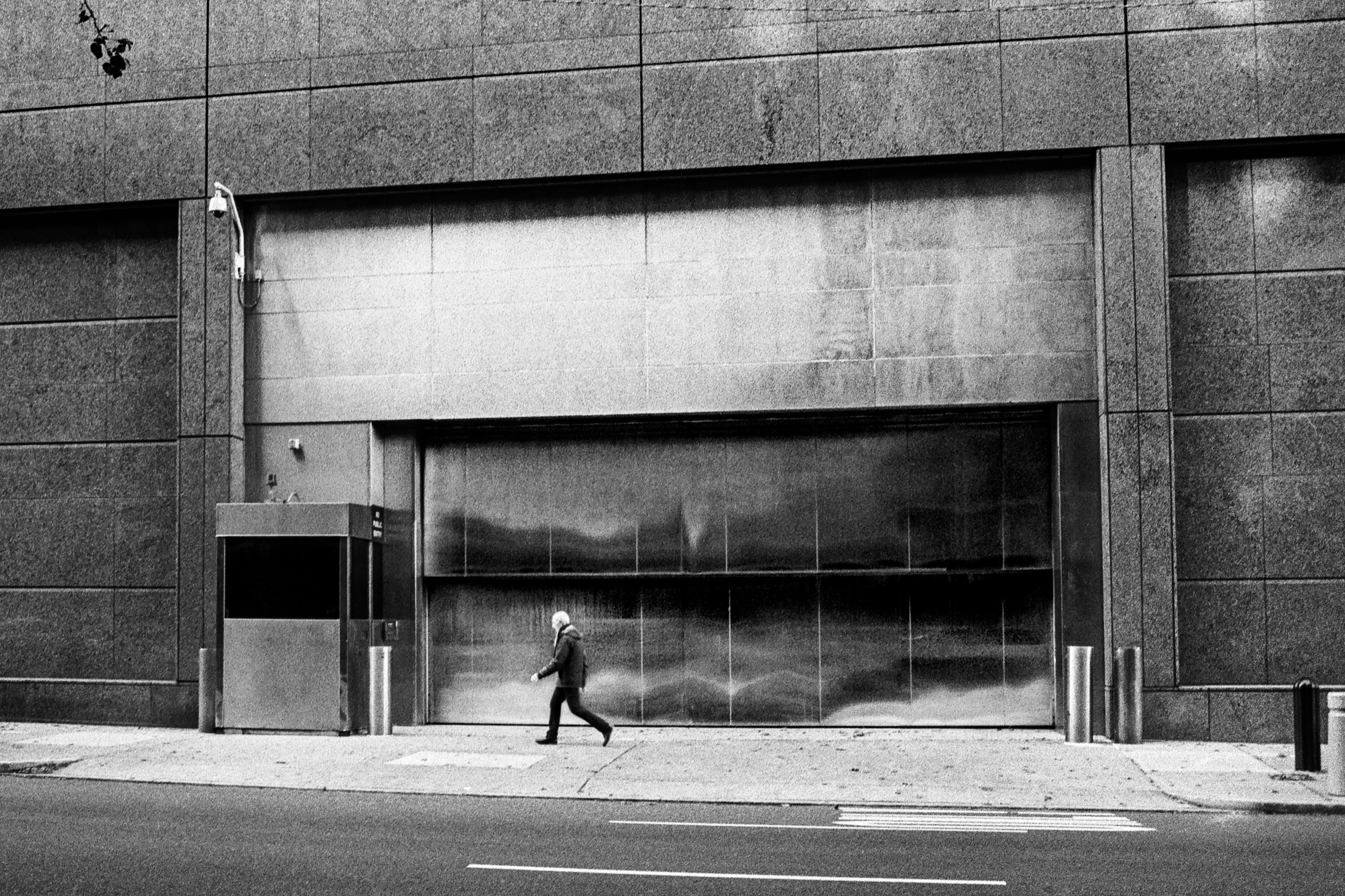 Black and white film photograph of a man walking